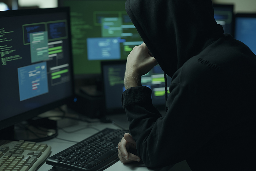 Hacker with hoodie working with a computer